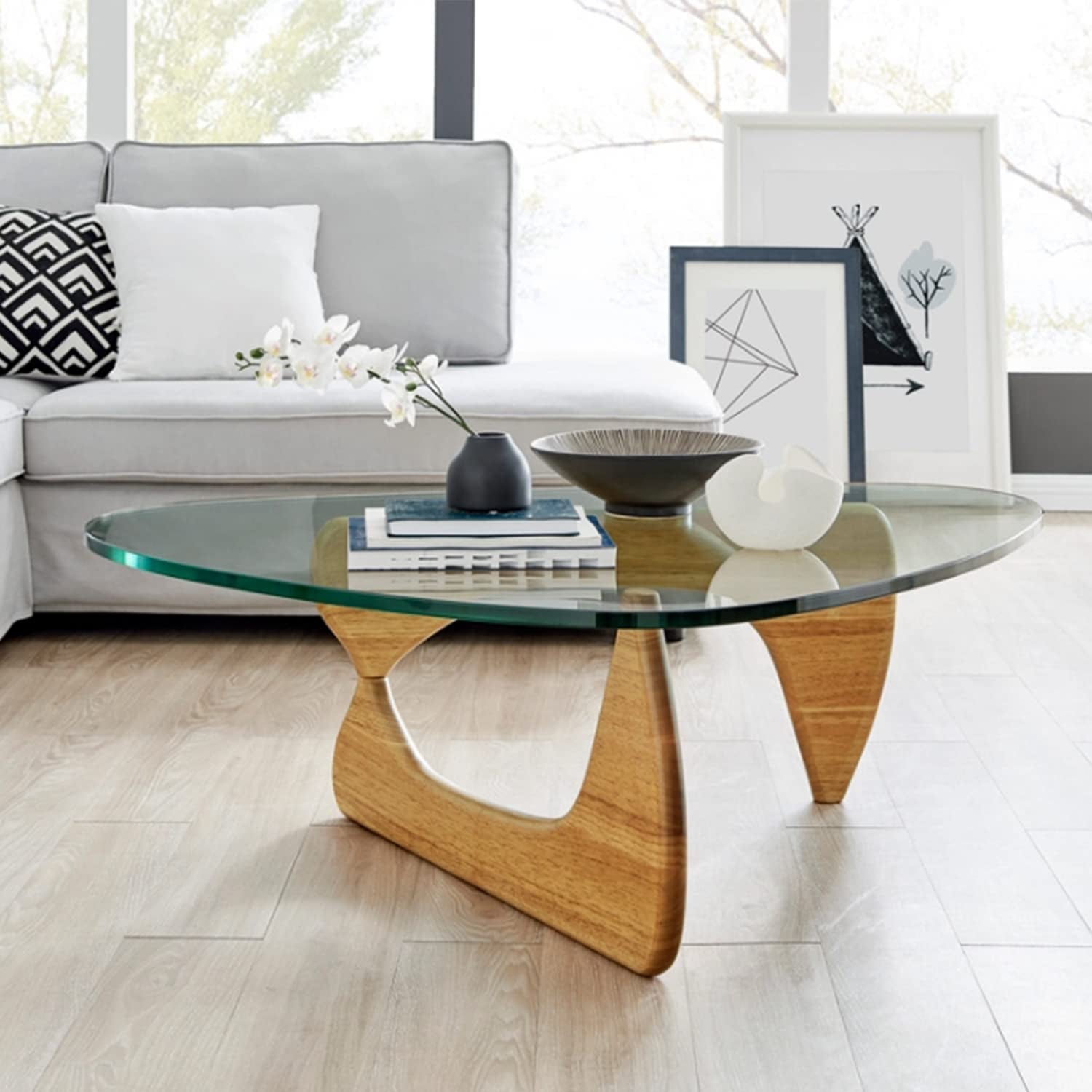 Modern glass coffee table with a wooden base in a stylish living room setting.