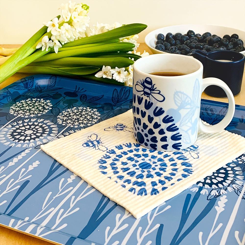 Swedish Dishcloths on a blue tray with flowers, a cup of coffee, and a bowl of blueberries.