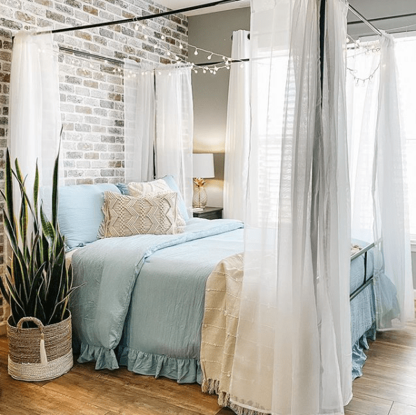 Elegant canopy bed in a bright bedroom, showcasing stylish decor with a modern touch. Canopy Beds.