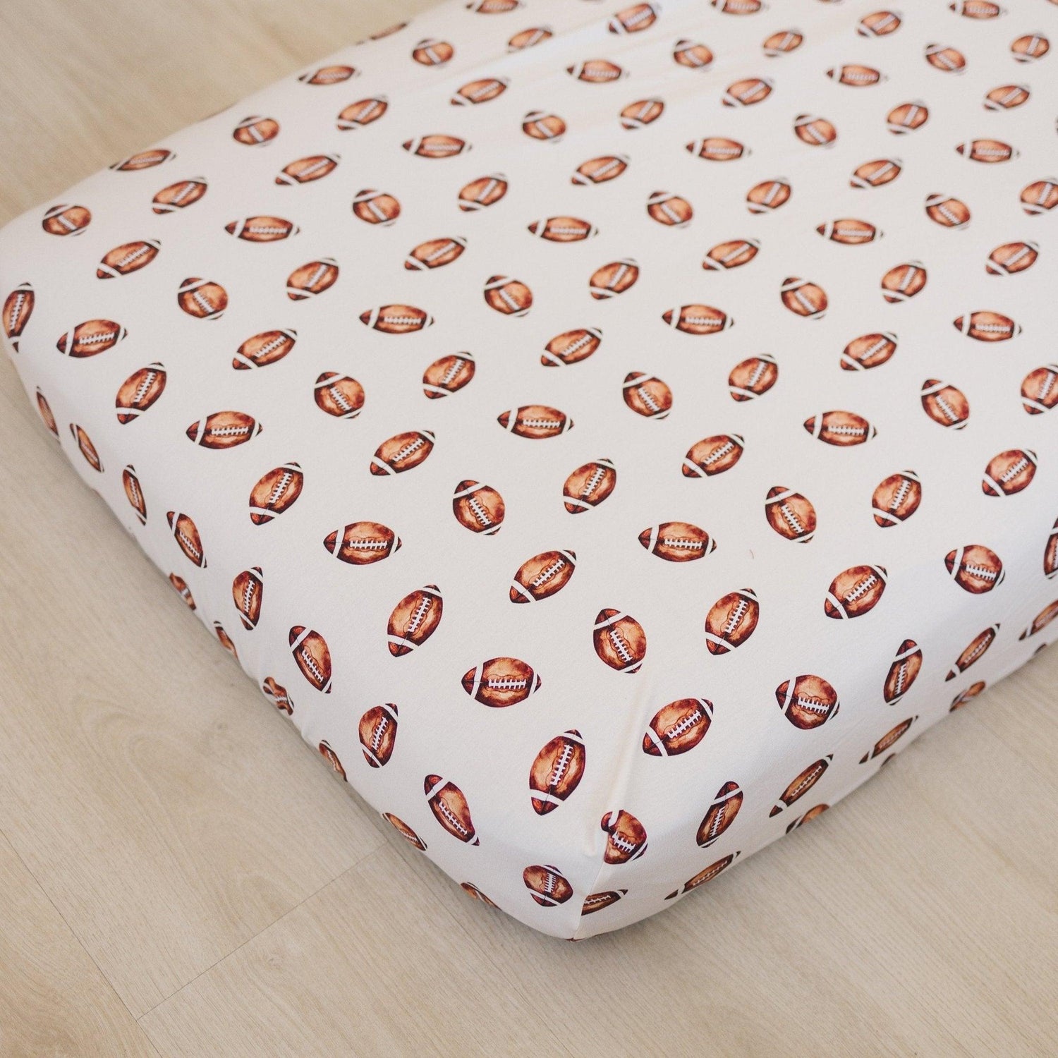 Crib Sheets with a fun football pattern for a playful nursery style.