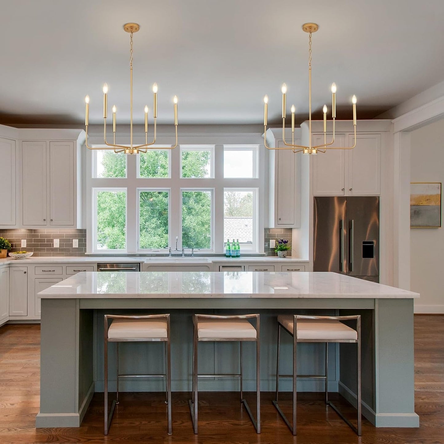 Gold 6 Light Candle Chandelier For Dining Room Modern illuminating a stylish kitchen island with white cabinetry.