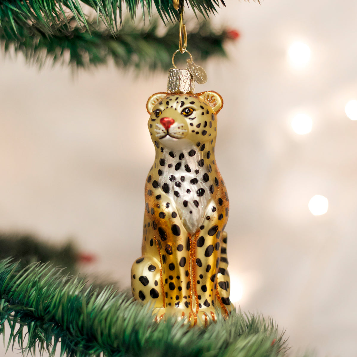 Leopard ornament hanging on a Christmas tree with blurred lights in the background