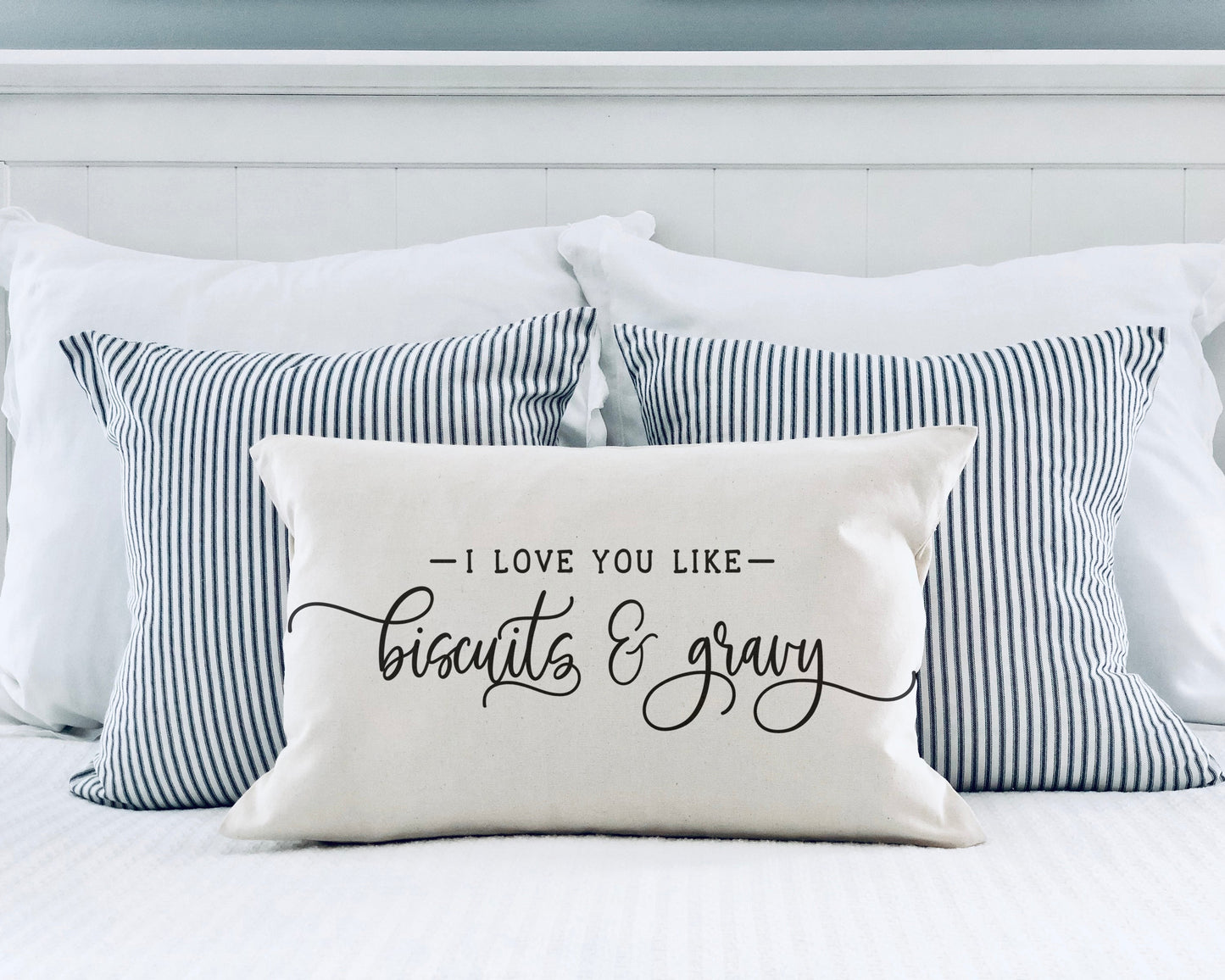 I Love You Like Biscuits and Gravy 12x20 inch Pillow Cover on a bed with striped pillows.