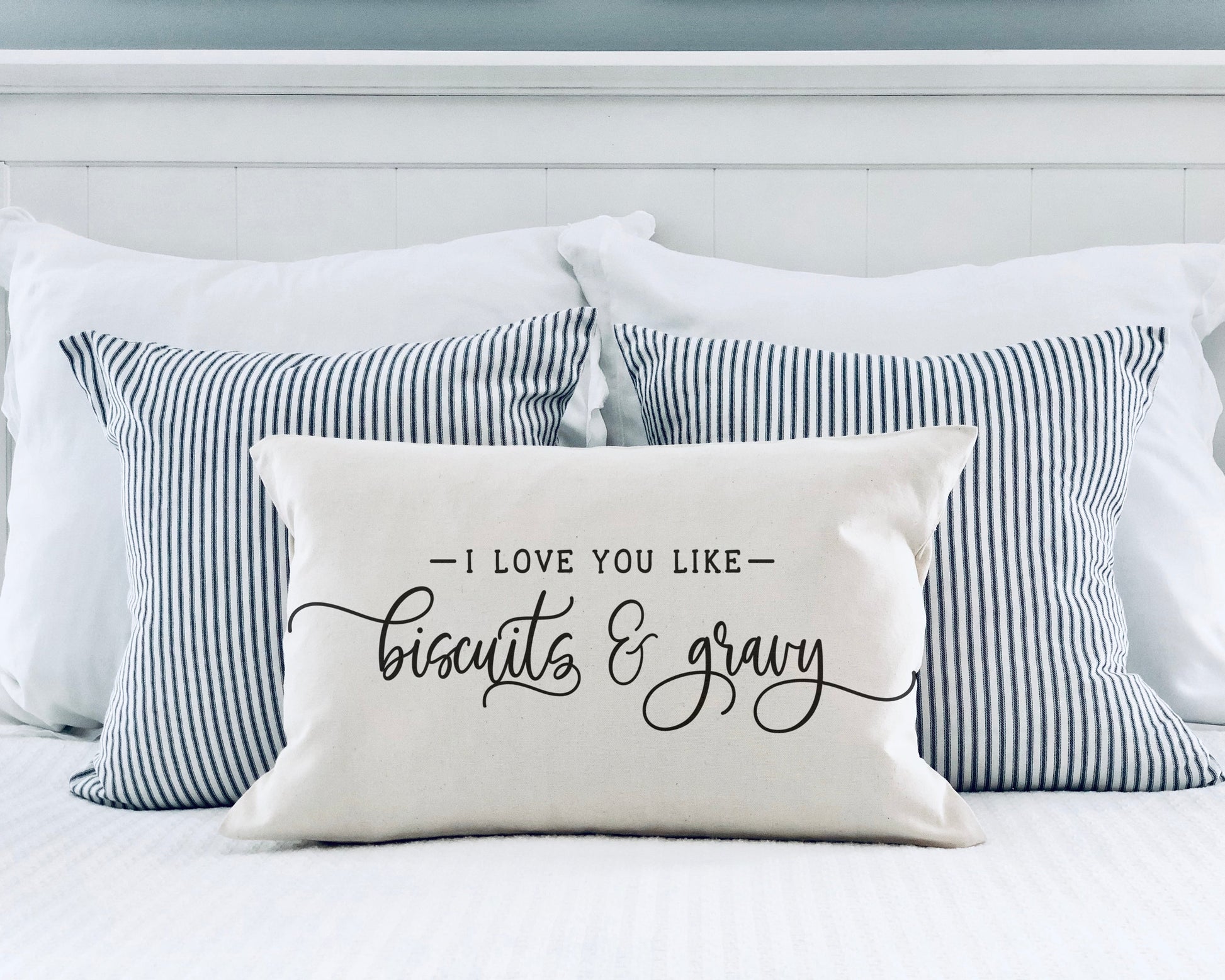 I Love You Like Biscuits and Gravy 12x20 inch Pillow Cover on a bed with striped pillows.