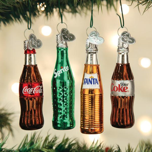 Decorative Christmas ornaments shaped like Coca-Cola, Sprite, Fanta, and Diet Coke bottles hanging on a tree.
