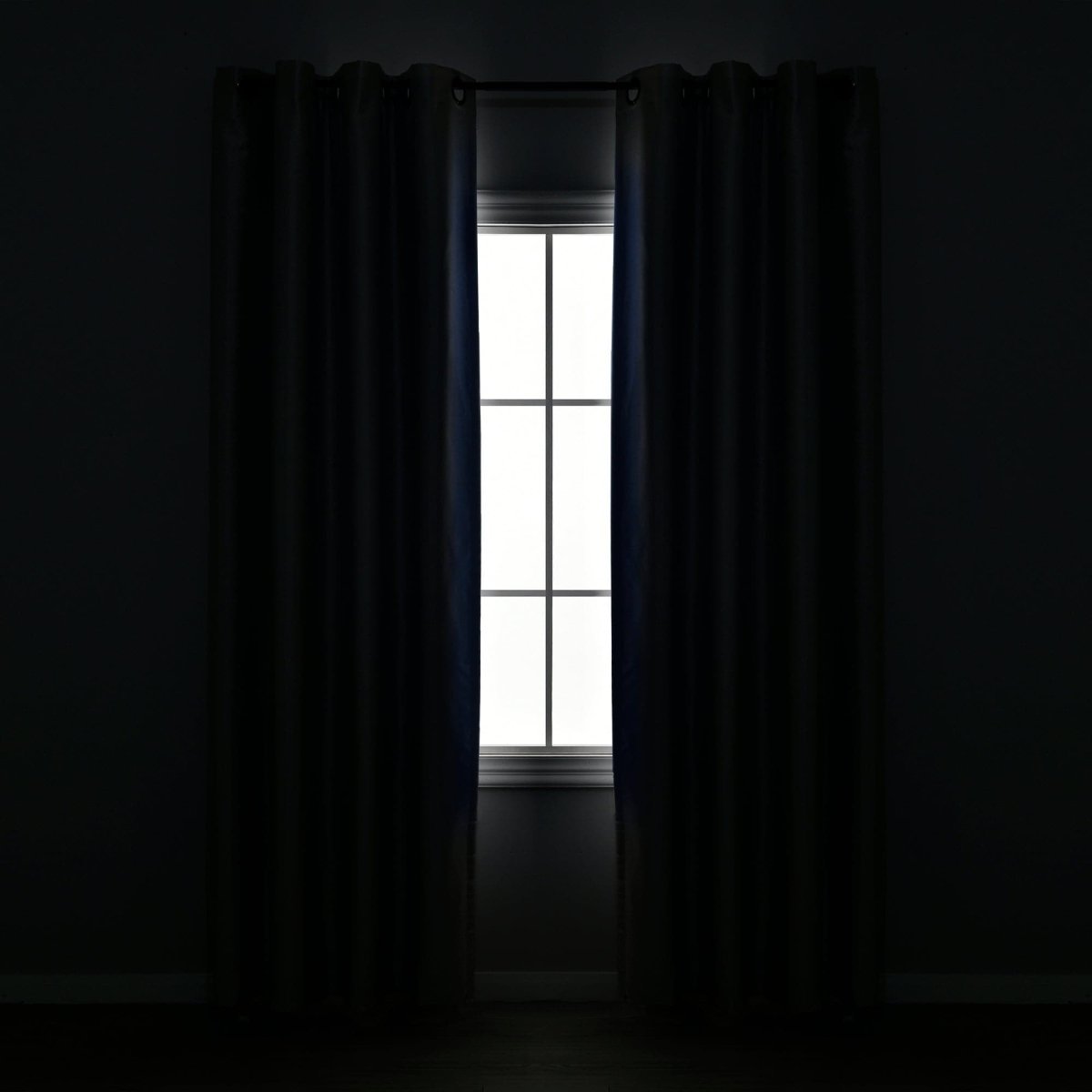 Faux Silk 100% Blackout Window Curtain framing a white window, offering full privacy in a dark room.