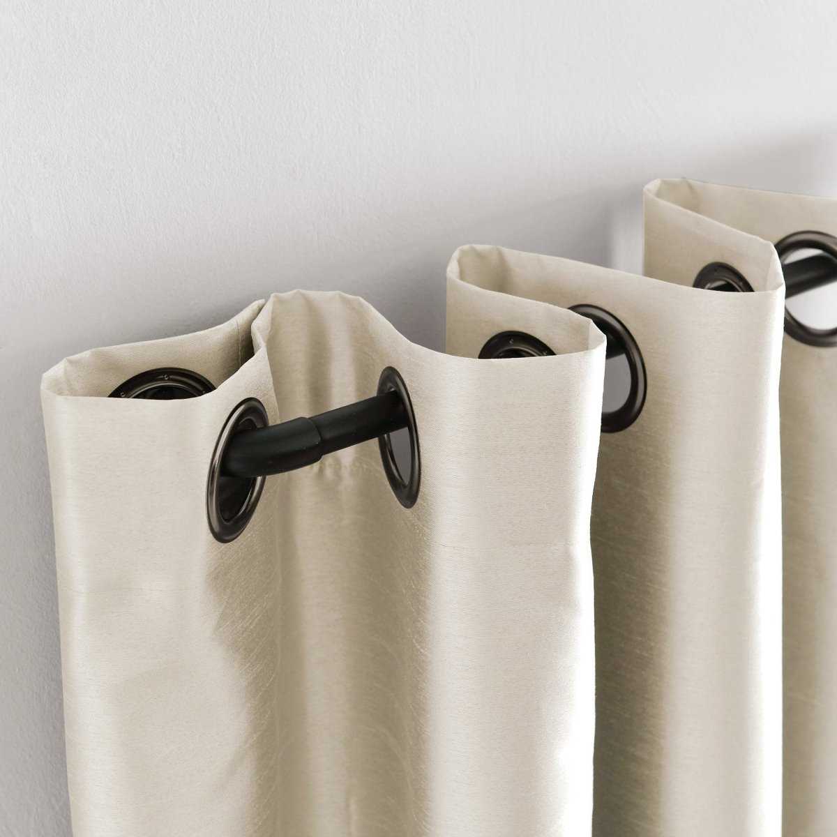 Faux Silk 100% Blackout Window Curtain panel with grommet top on a rod, showcasing luxurious solid texture and elegant design.