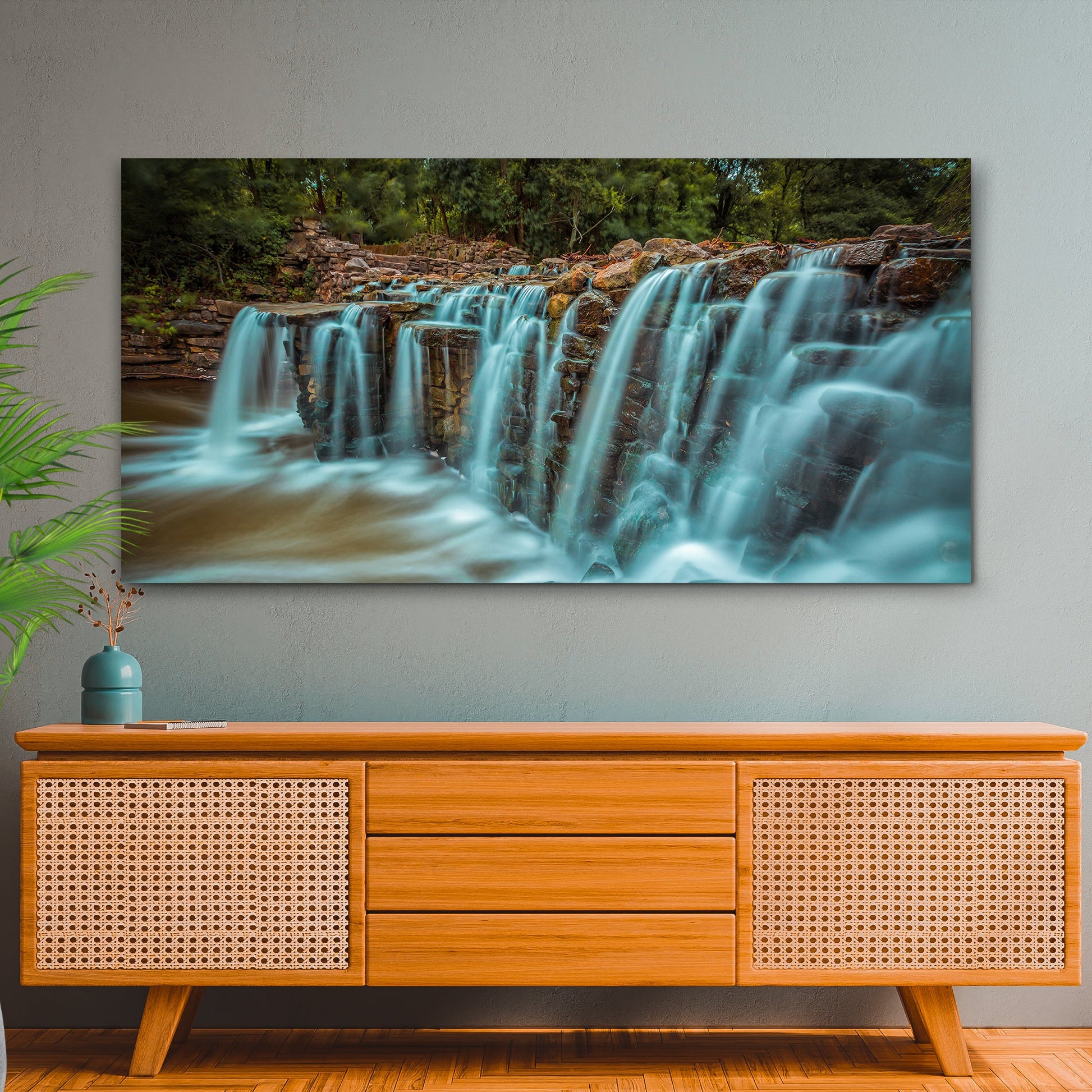 Panoramic view of a waterfall on a wall above a wooden cabinet.
