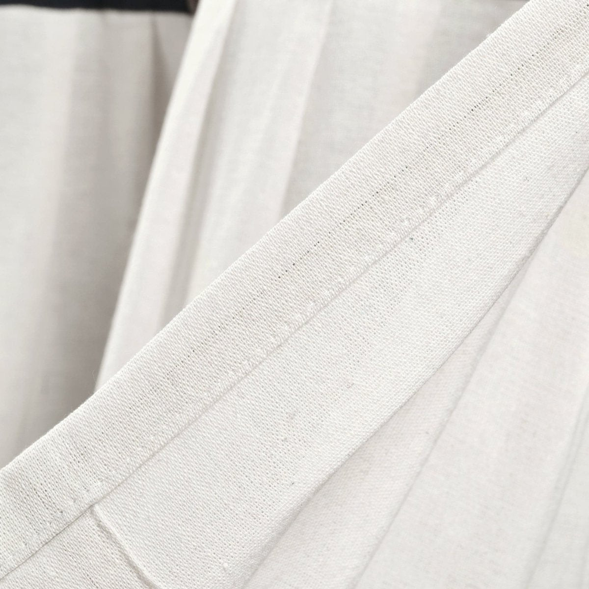 Close-up of Linen Button Valance fabric showcasing its natural fiber texture and elegant pleats.