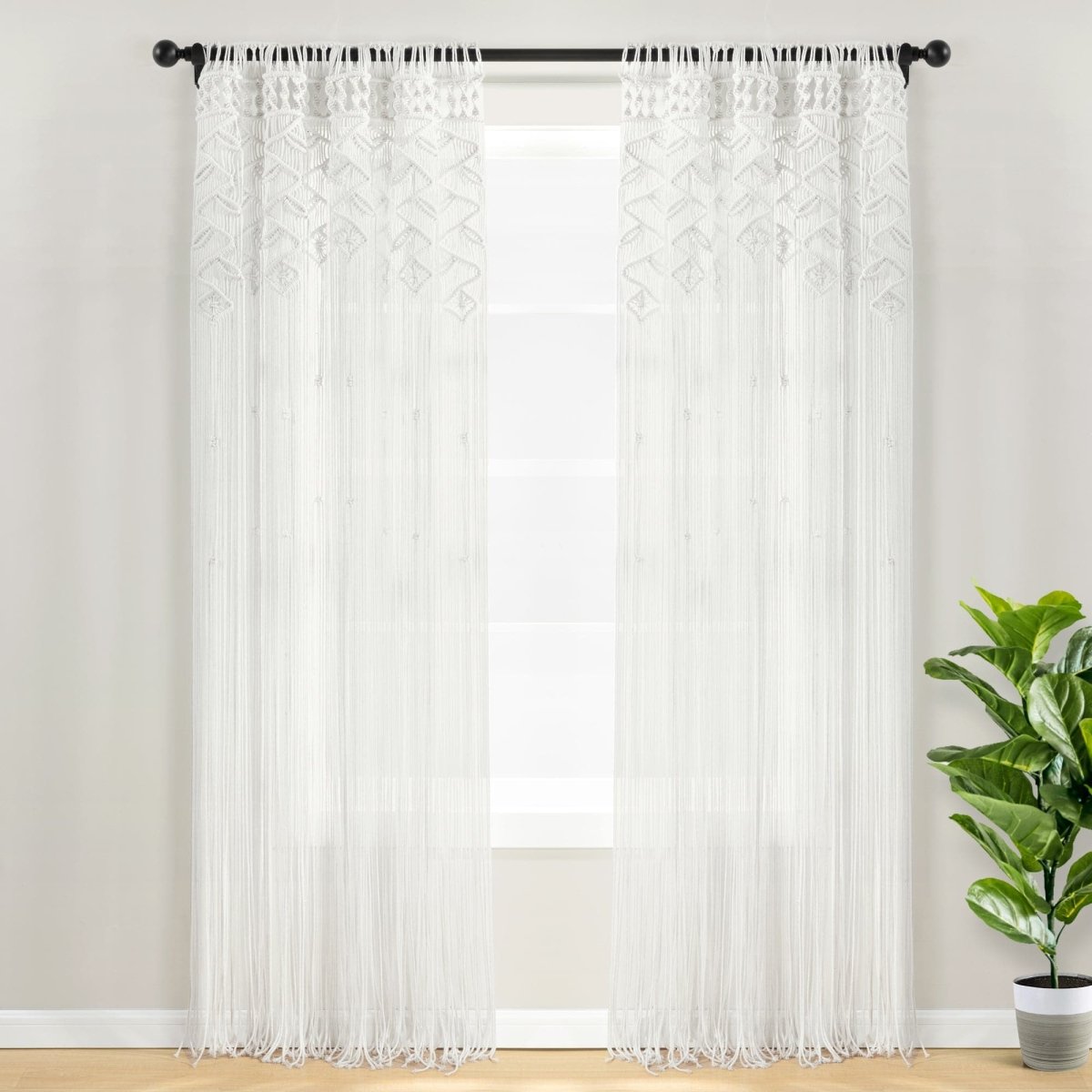 Boho Macrame Leaf Cotton Window Curtain displayed in a bright room with a potted plant.