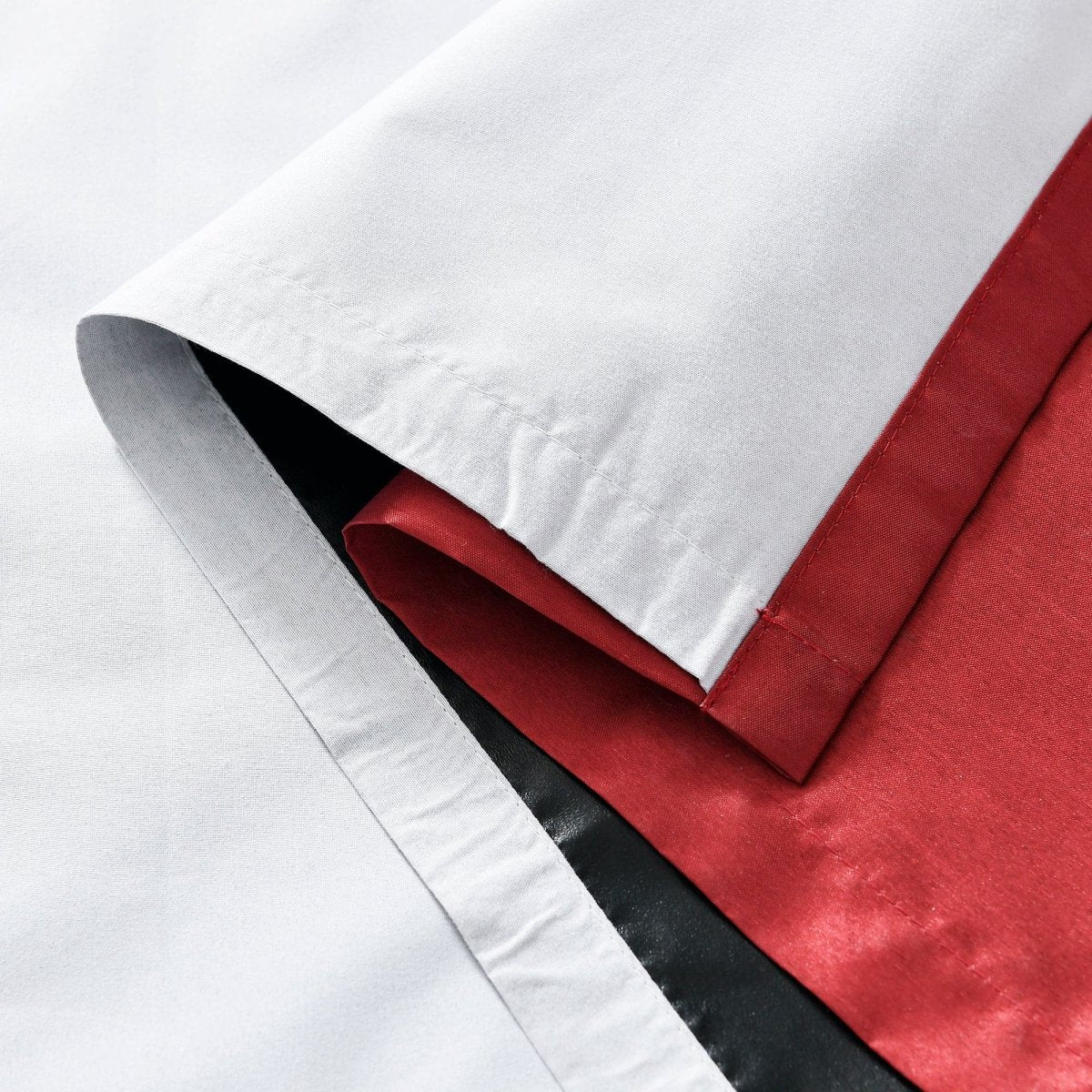 Close-up of Faux Silk fabric showcasing red and black colors, highlighting the luxurious texture of the material for a Blackout Window Curtain.