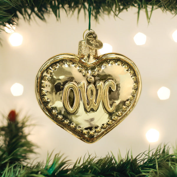 Gold heart-shaped ornament with 'OWC' on a Christmas tree