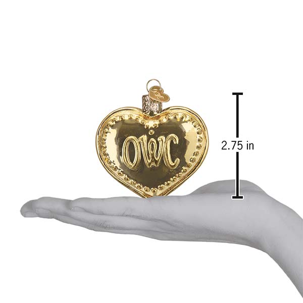 Gold heart-shaped ornament with 'OWC' initials on a hand for scale, against a white background.