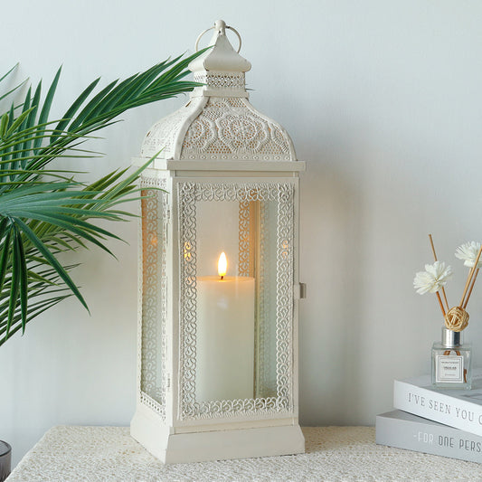 Rustic Metal Decorative Candle Lantern Hanging Candle Holder with Tempered Glass White with lit candle and decorative plants.