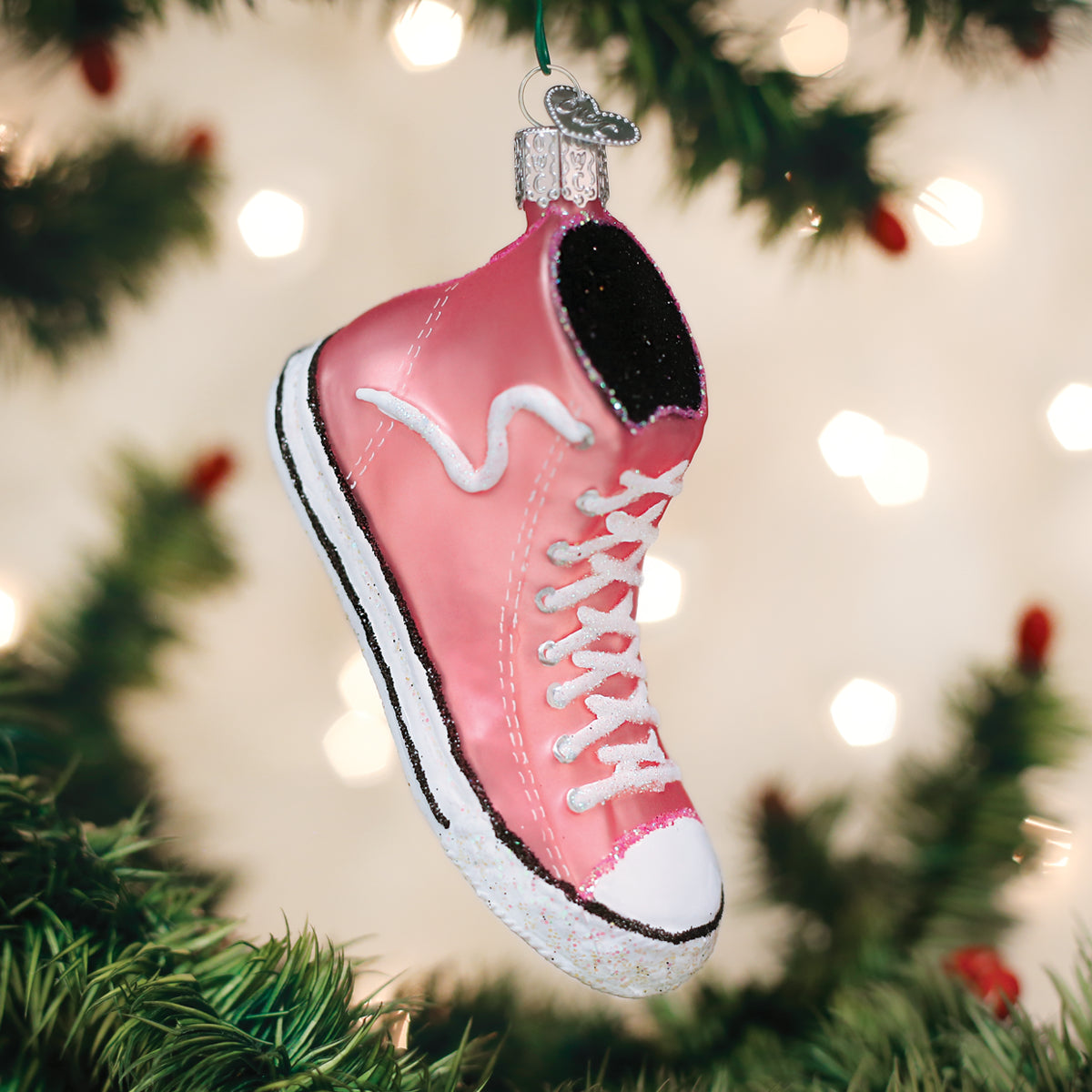 Pink sneaker ornament on a Christmas tree with blurred lights in the background