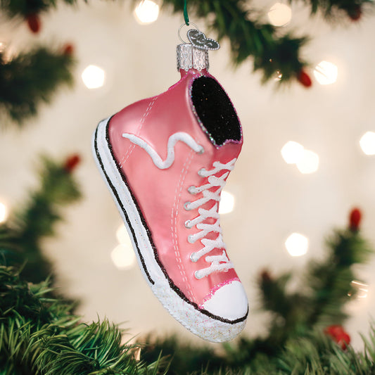 Pink sneaker ornament on a Christmas tree with blurred lights in the background