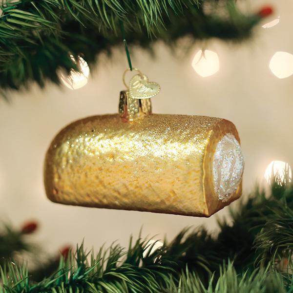 Gold glittery Twinkie ornament on a Christmas tree with blurred lights in the background