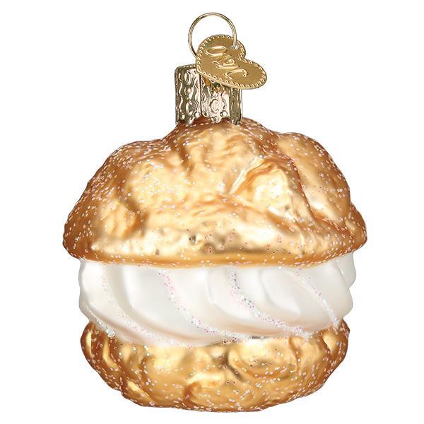 Decorative glass ornament shaped like a pastry with white cream filling on a white background