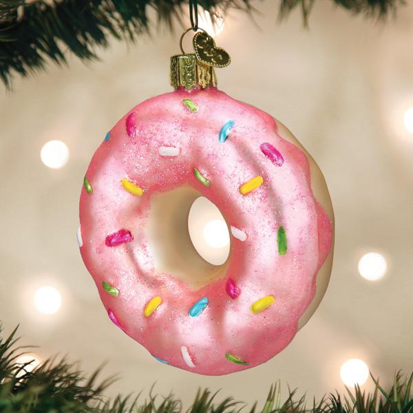 Pink donut ornament with sprinkles on a Christmas tree