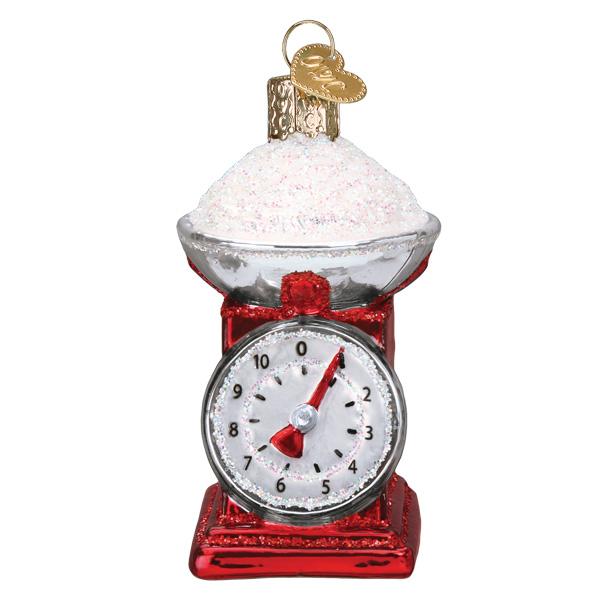 Decorative kitchen scale ornament with red base and white face on a white background