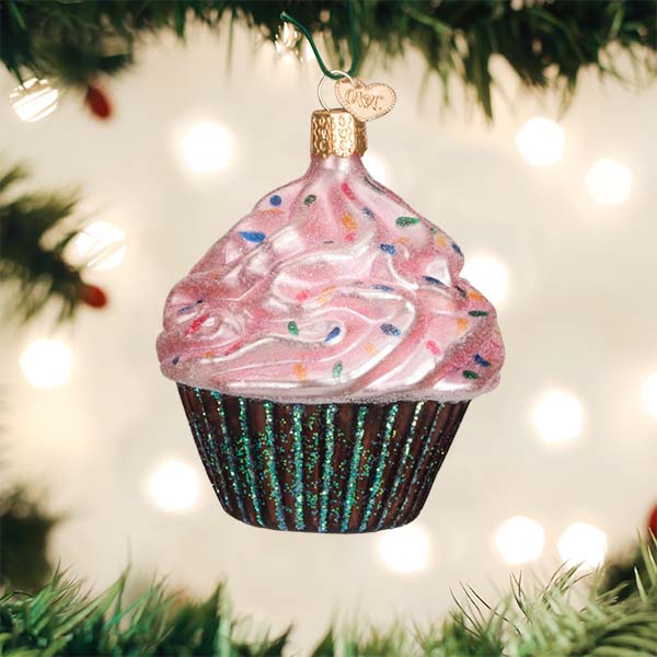 Decorative cupcake ornament on a Christmas tree with lights in the background