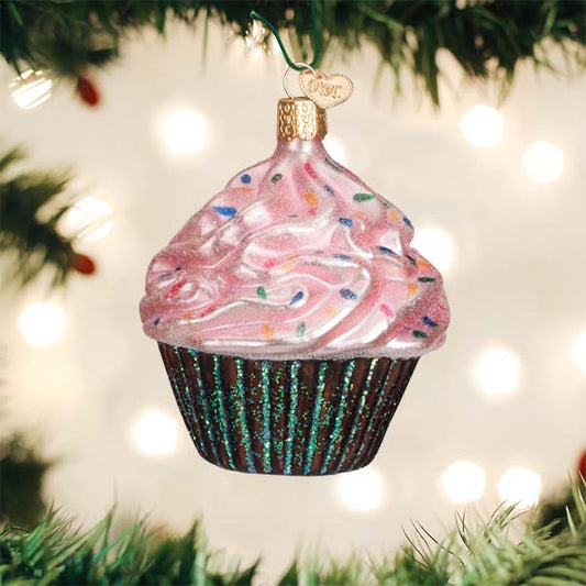 Decorative cupcake ornament on a Christmas tree with lights in the background