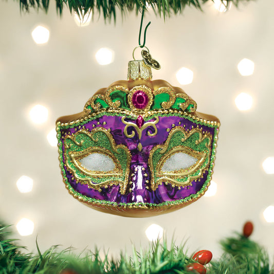 Decorative mask ornament on a Christmas tree with lights in the background