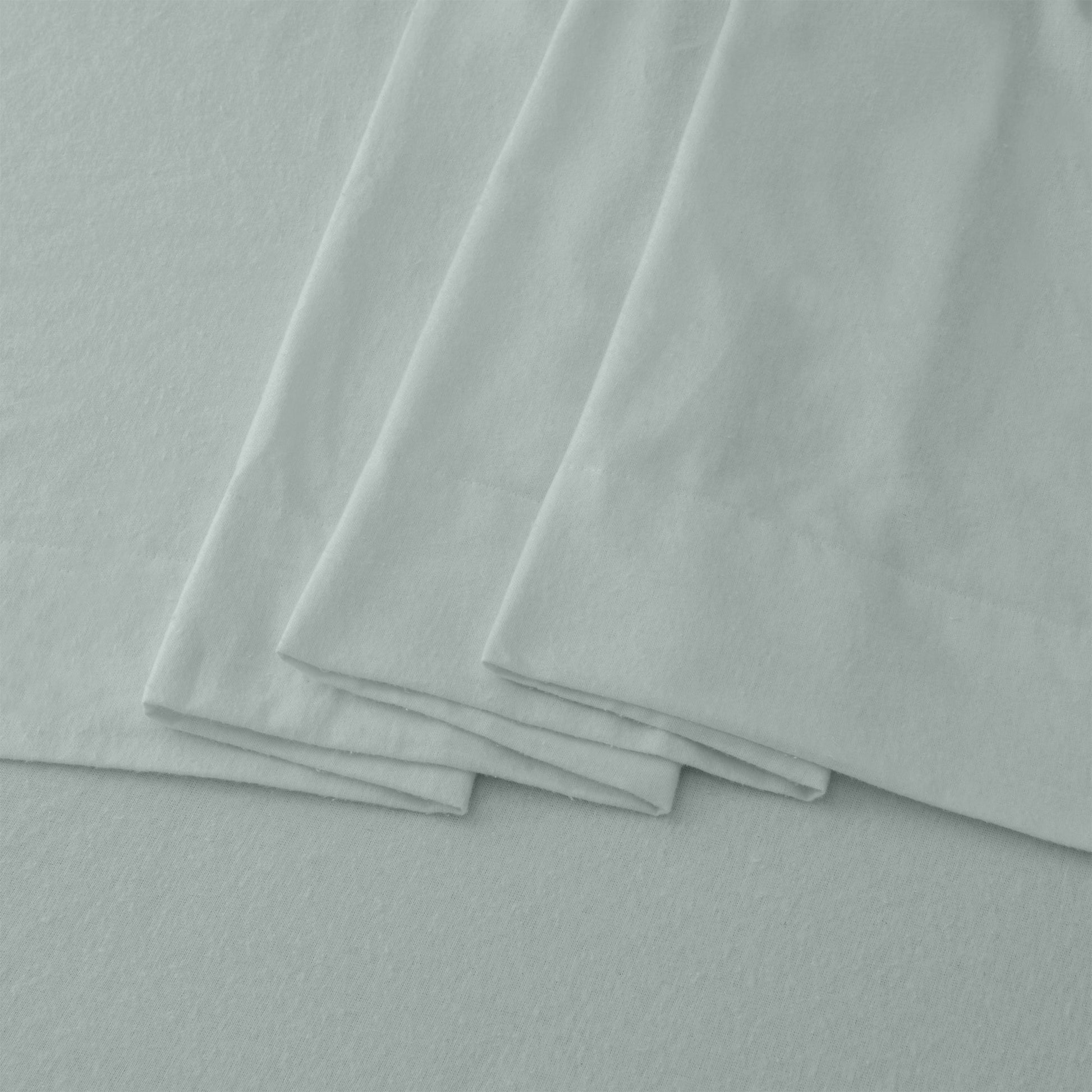 Stack of light gray fabric sheets on a matching background