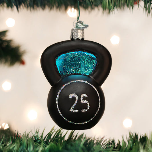 Black kettlebell ornament with blue glitter and '25' on a Christmas tree.