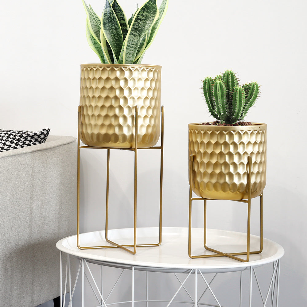 2 Set of 17&12 Inch Tall Planters With Stand Gold on a decorative table with plants.