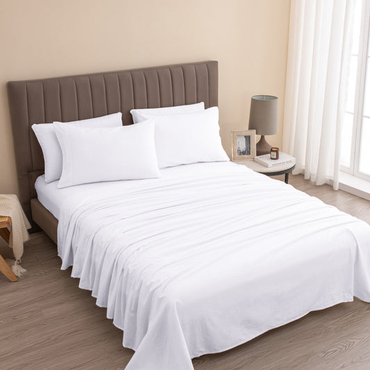 Bedroom with a neatly made bed featuring white bedding and pillows.