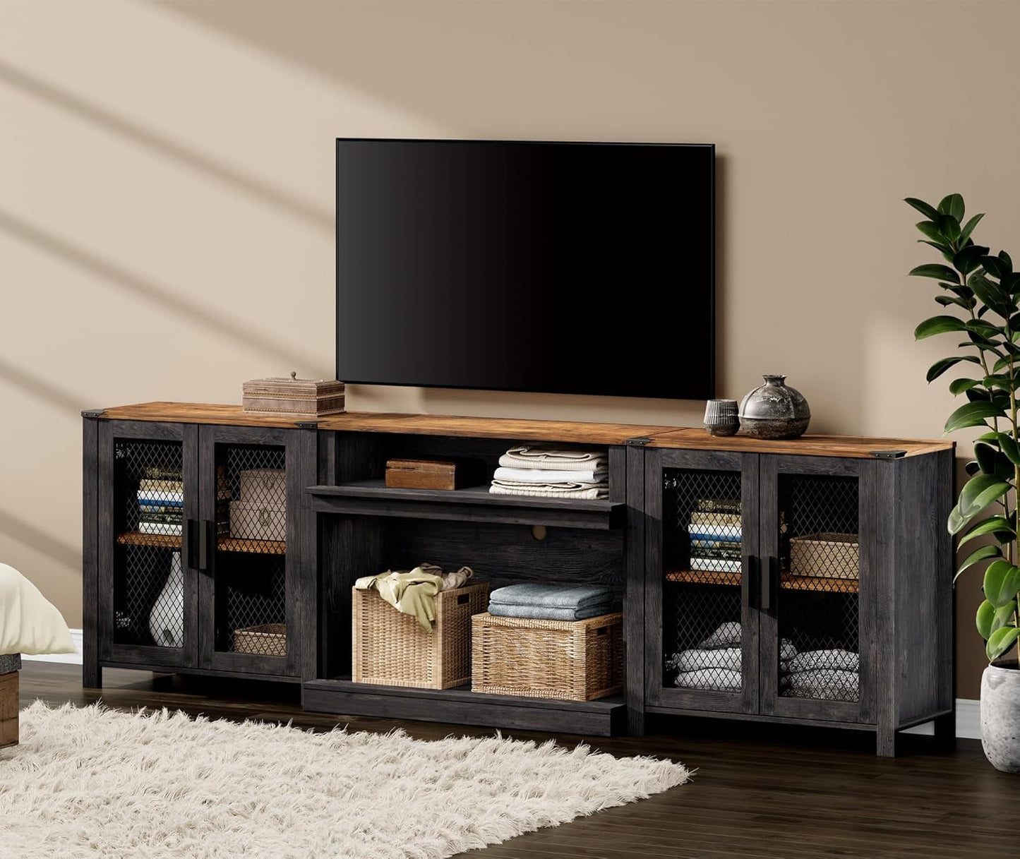TV stand with a television on top in a room with a plant and rug.
