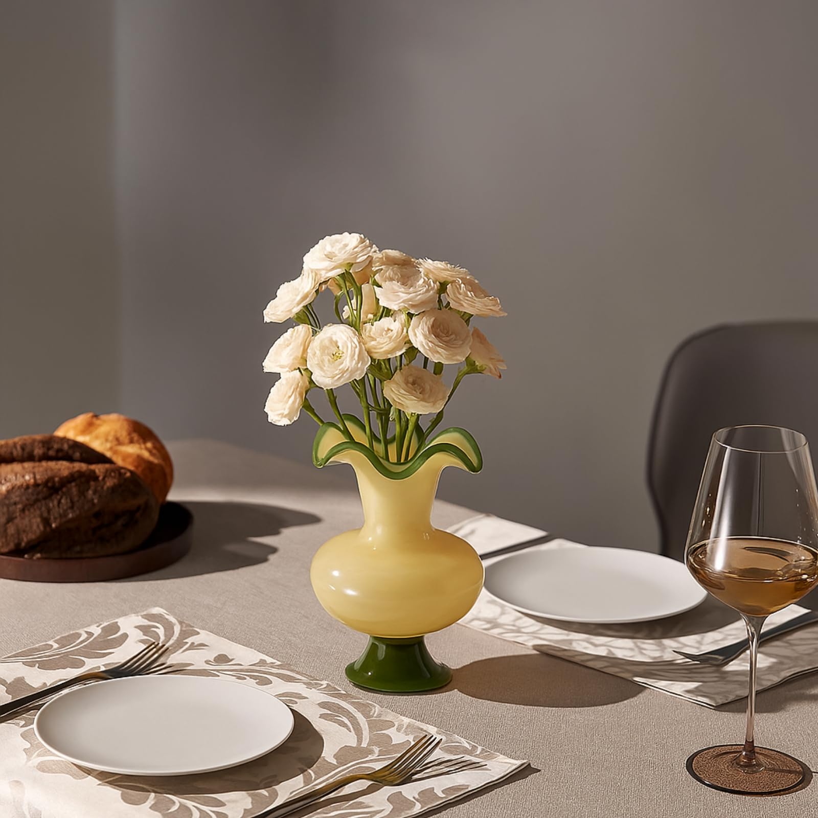 Glass Meadow Hand-Blown Glass Flower Vase holding cream flowers on a dining table with bread and wine.