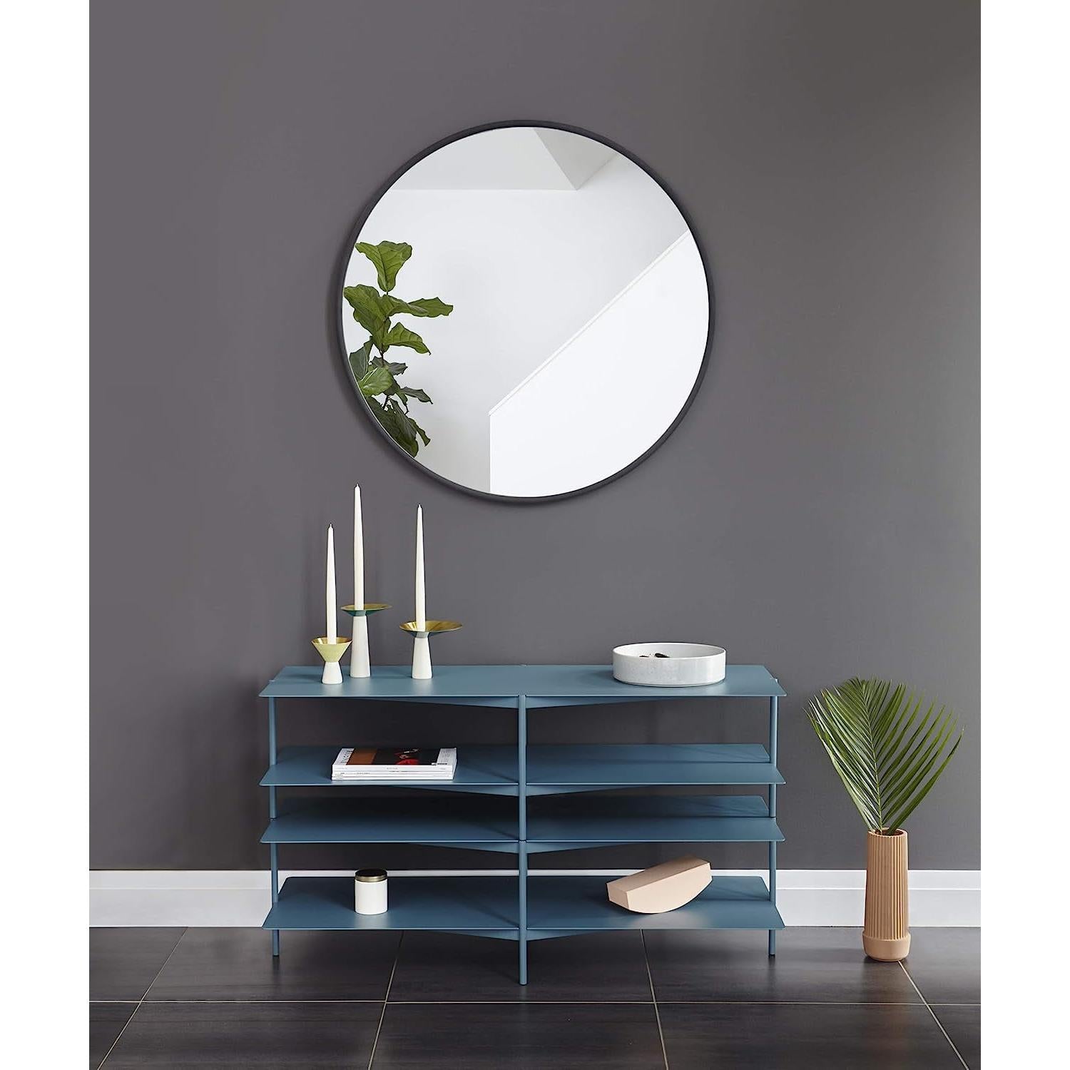 Round Rubber Wall Mirror 37 Inch diameter above a modern blue console table with candles and greenery.