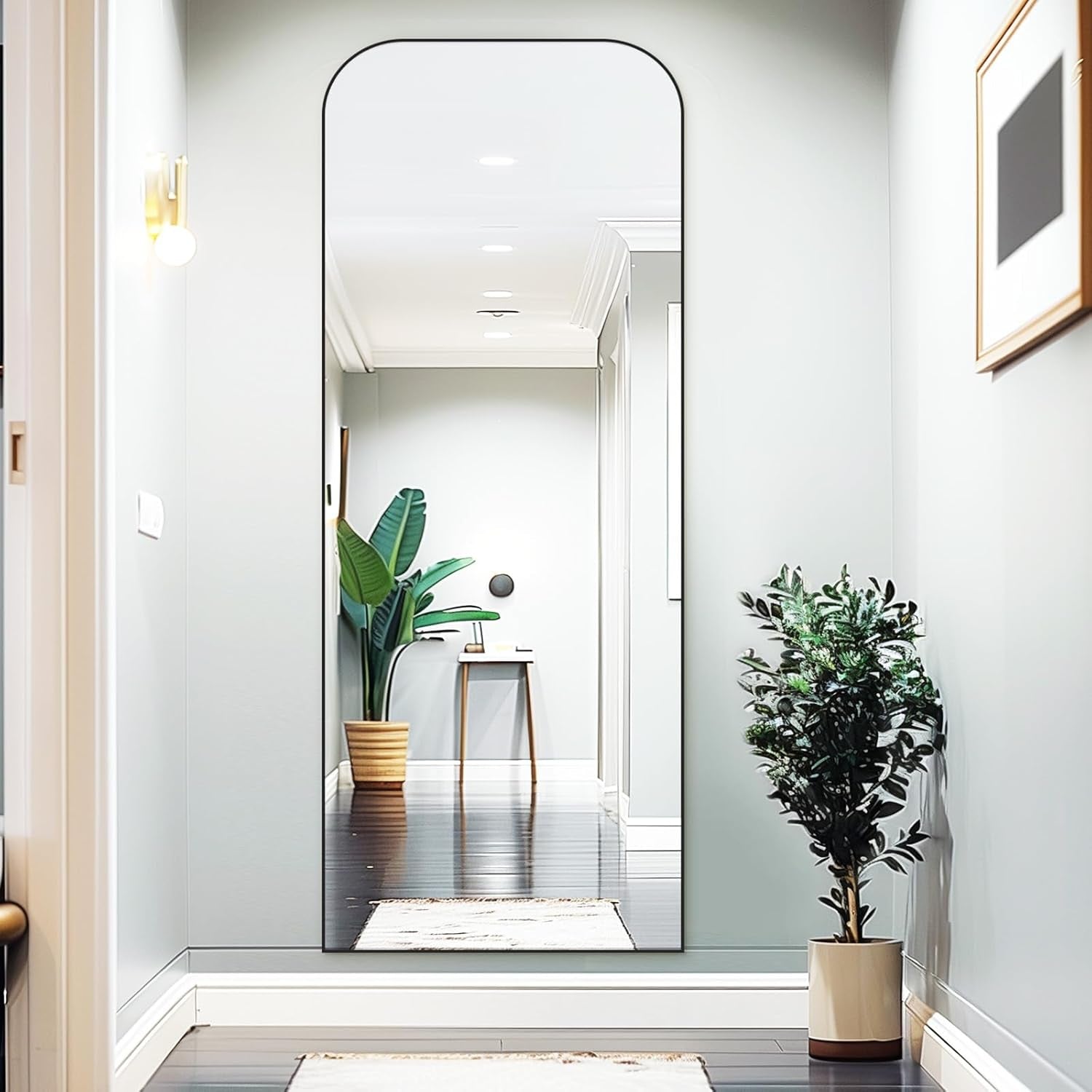 71 Inch Black Oversized Full Length Arch Floor Mirror reflecting stylish hallway with plants and modern decor.