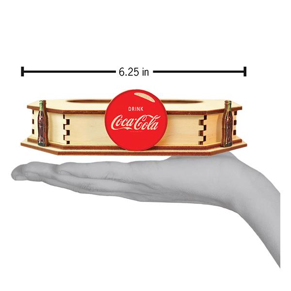 Coca-Cola branded wooden tealight holder with a hand holding it for scale on a white background