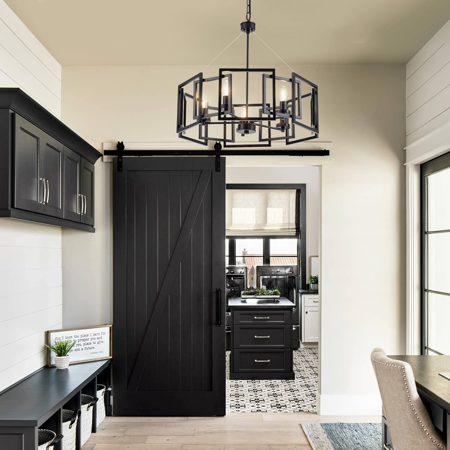 Industrial Style Five Light Matte Black Pendant Chandelier hanging in a modern kitchen with black cabinetry and sliding door.