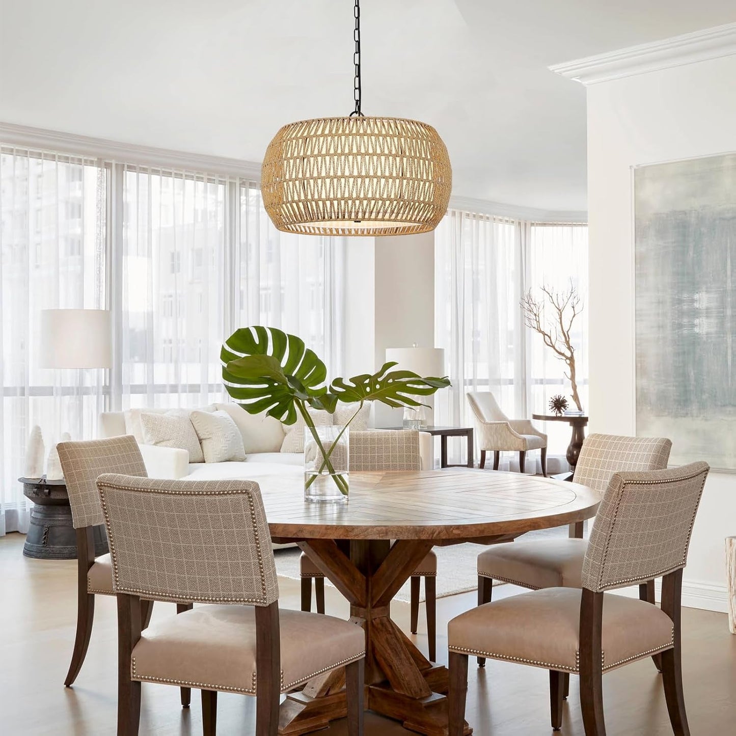 Rattan Farmhouse 5 Light Chandelier With Fabric Shade hanging above a rustic dining table with stylish chairs.