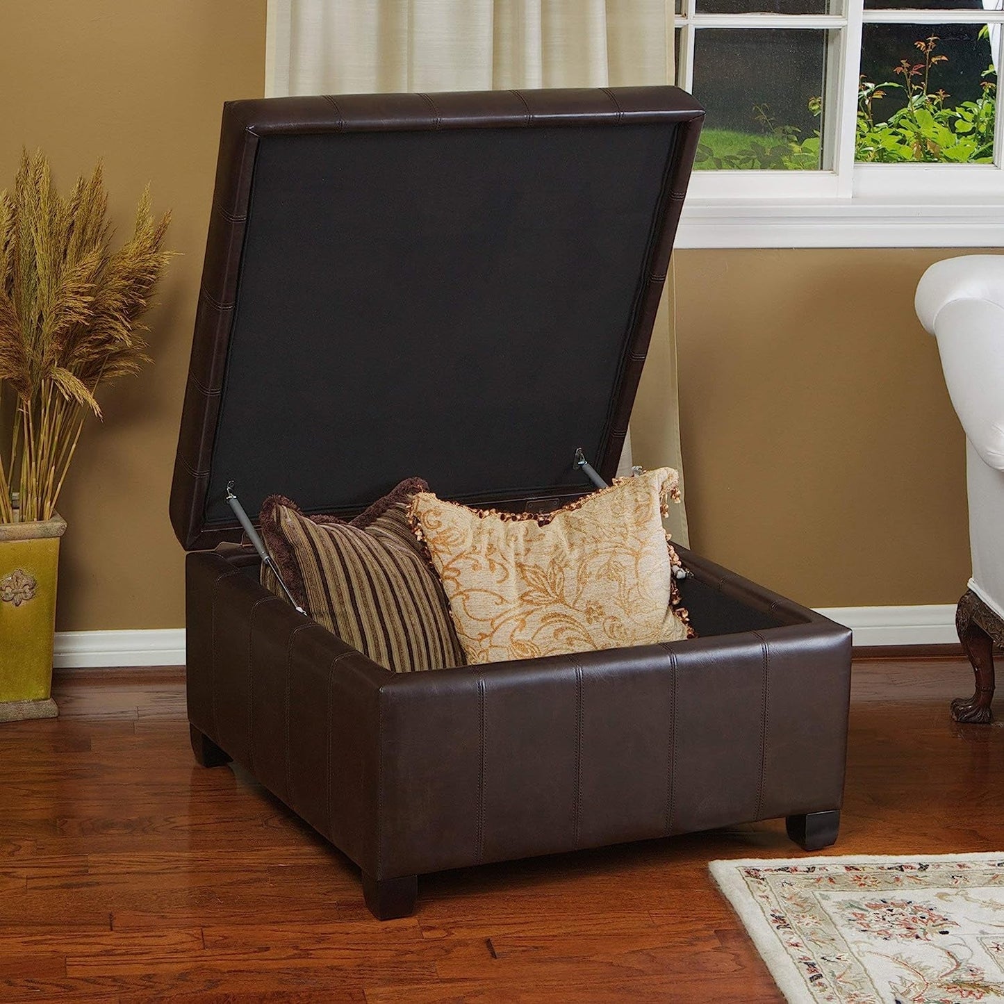 Marbled Brown Leather Storage Ottoman for Living Room with pillows and tufted lid opened.