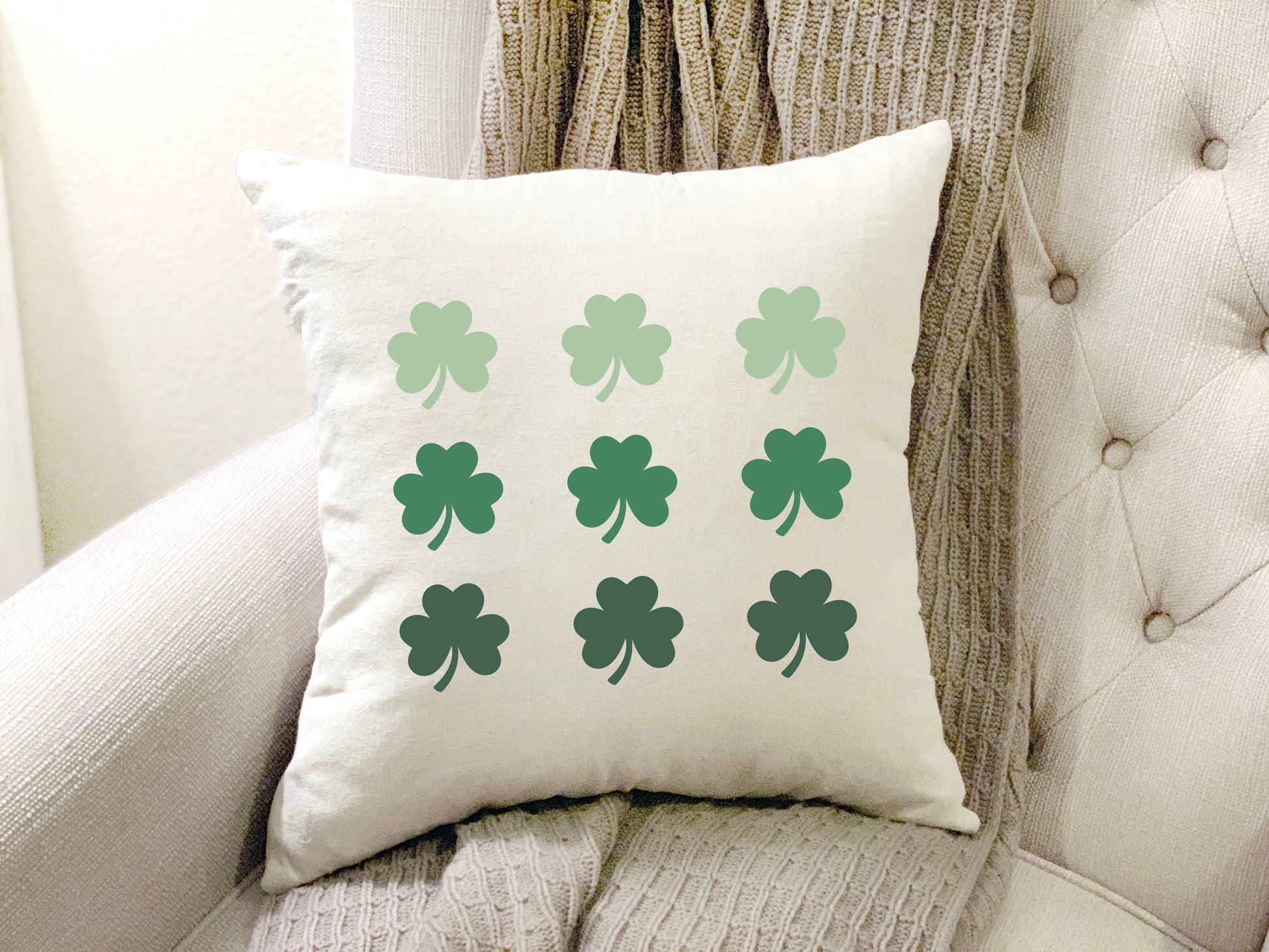 9 Shamrocks 18x18 inch St. Patrick's Day Pillow Cover displayed on a cozy chair.