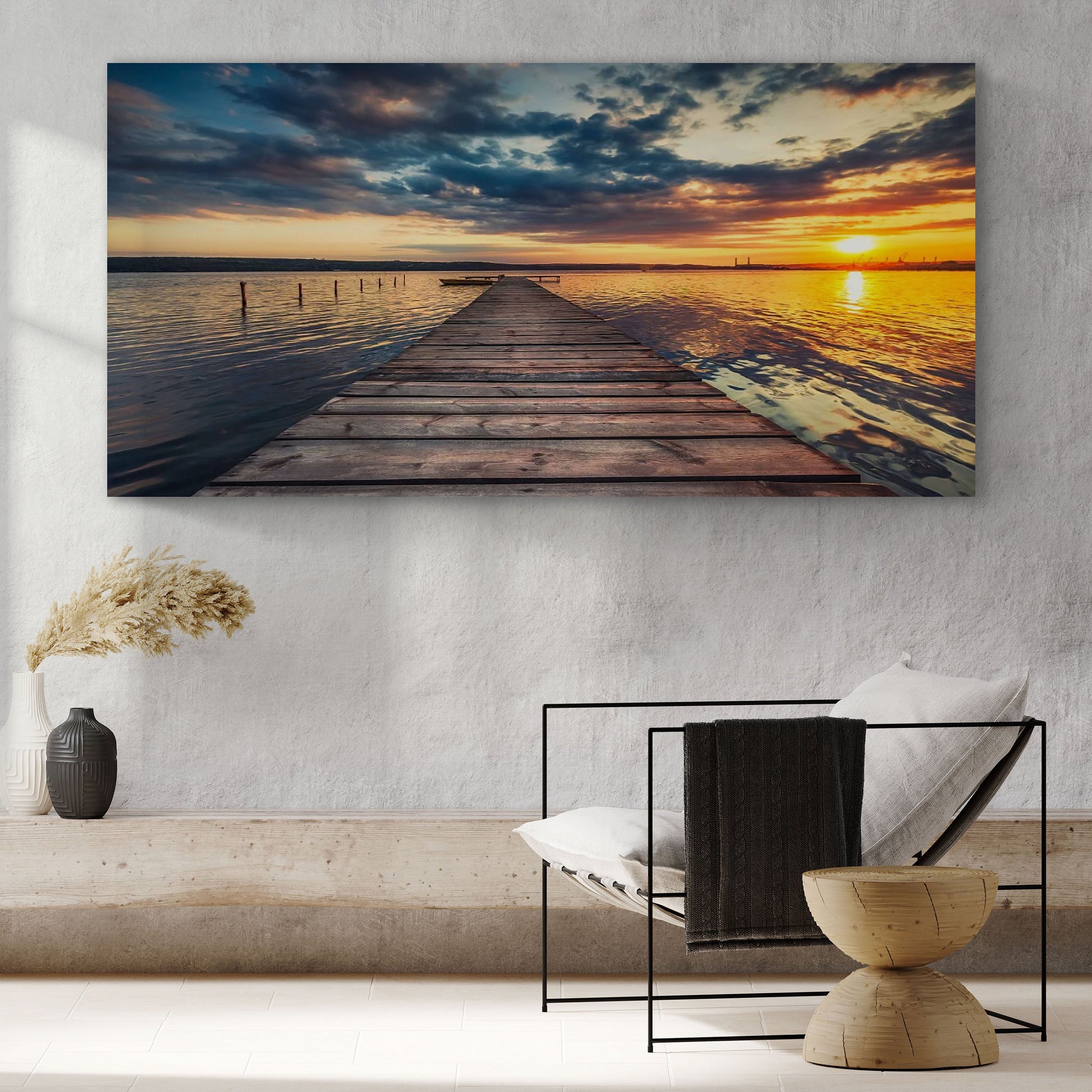 Canvas print of a sunset over a dock on a wall above a living room setup.