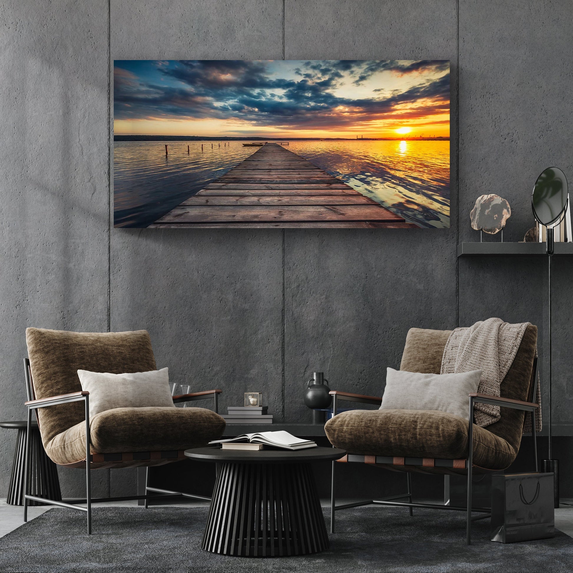 Modern living room with two armchairs, a coffee table, and a large sunset over water painting on the wall.
