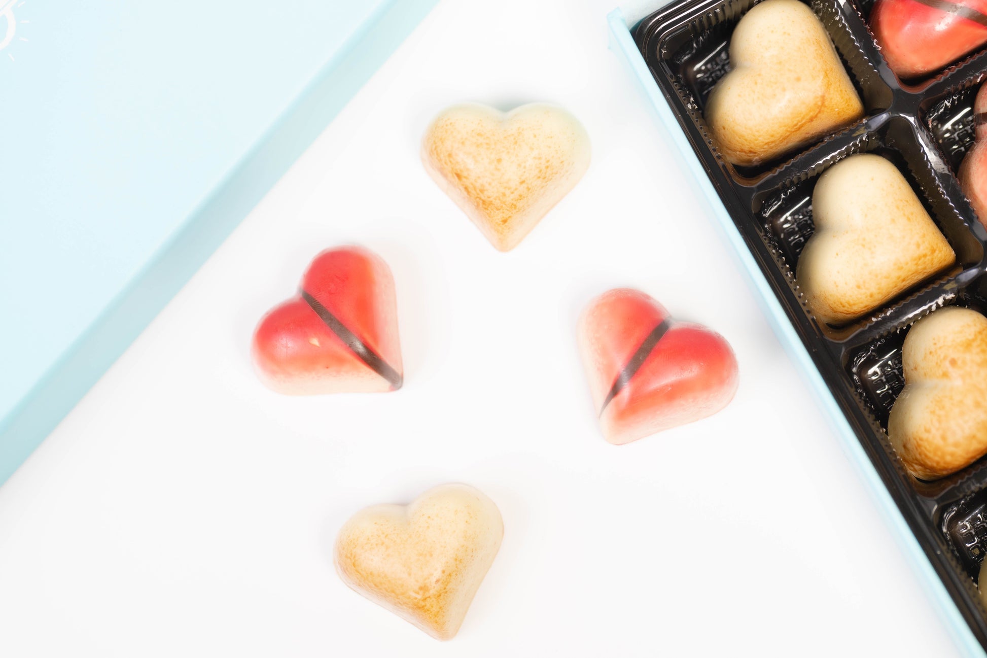 Heart-shaped chocolates on a white surface with a blue border