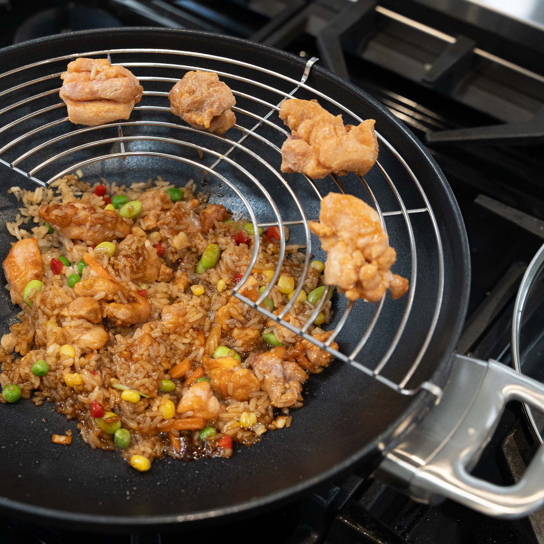 CXD PFAS Free Nonstick Wok with Lid and Rack - 12.5 32 cm 5.3 QT 5 L stir-frying rice and chicken on a stovetop.