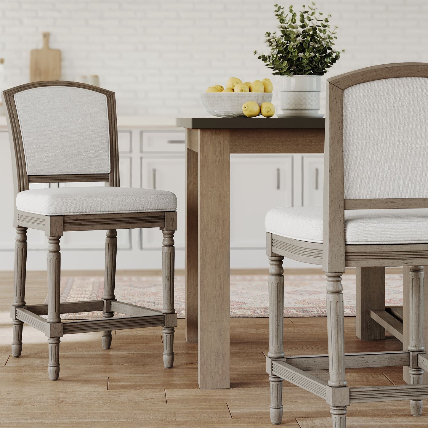 Wilmington Stool In Natural Gray positioned near a dining table with a bowl of lemons.