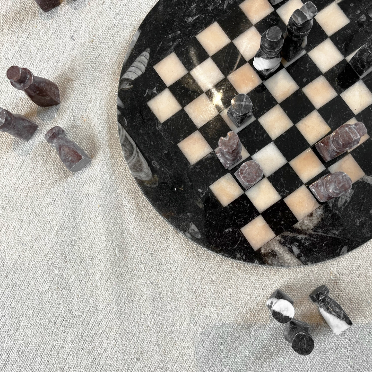 Stone Chess Set featuring a handcrafted stone board and unique pieces on a textured fabric background.