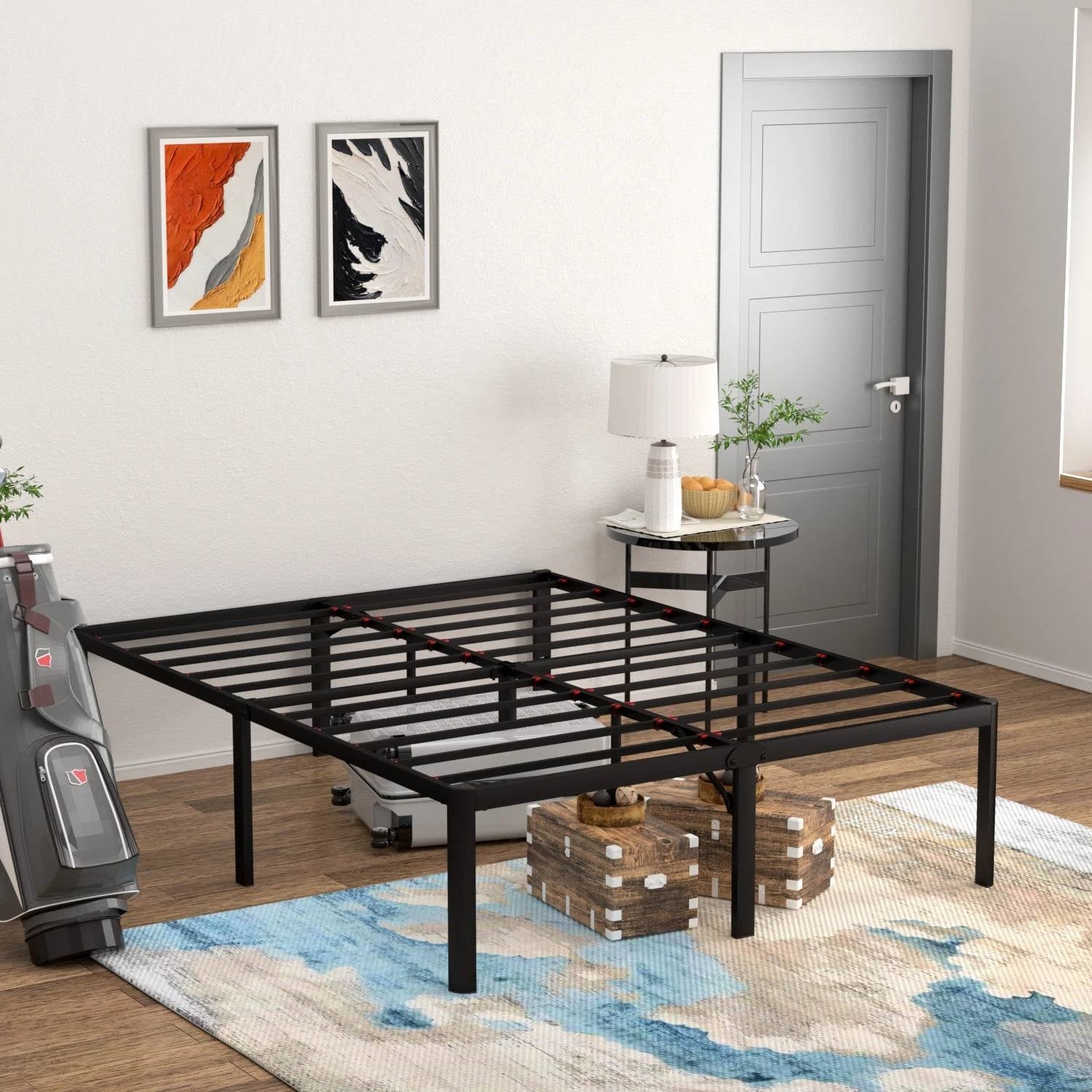 Black metal bed frame in a room with a rug, table, and door.