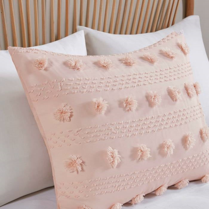 Pink decorative pillow with floral patterns on a bed