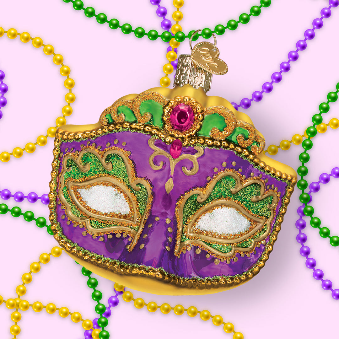 Decorative Mardi Gras mask with beads on a pink background