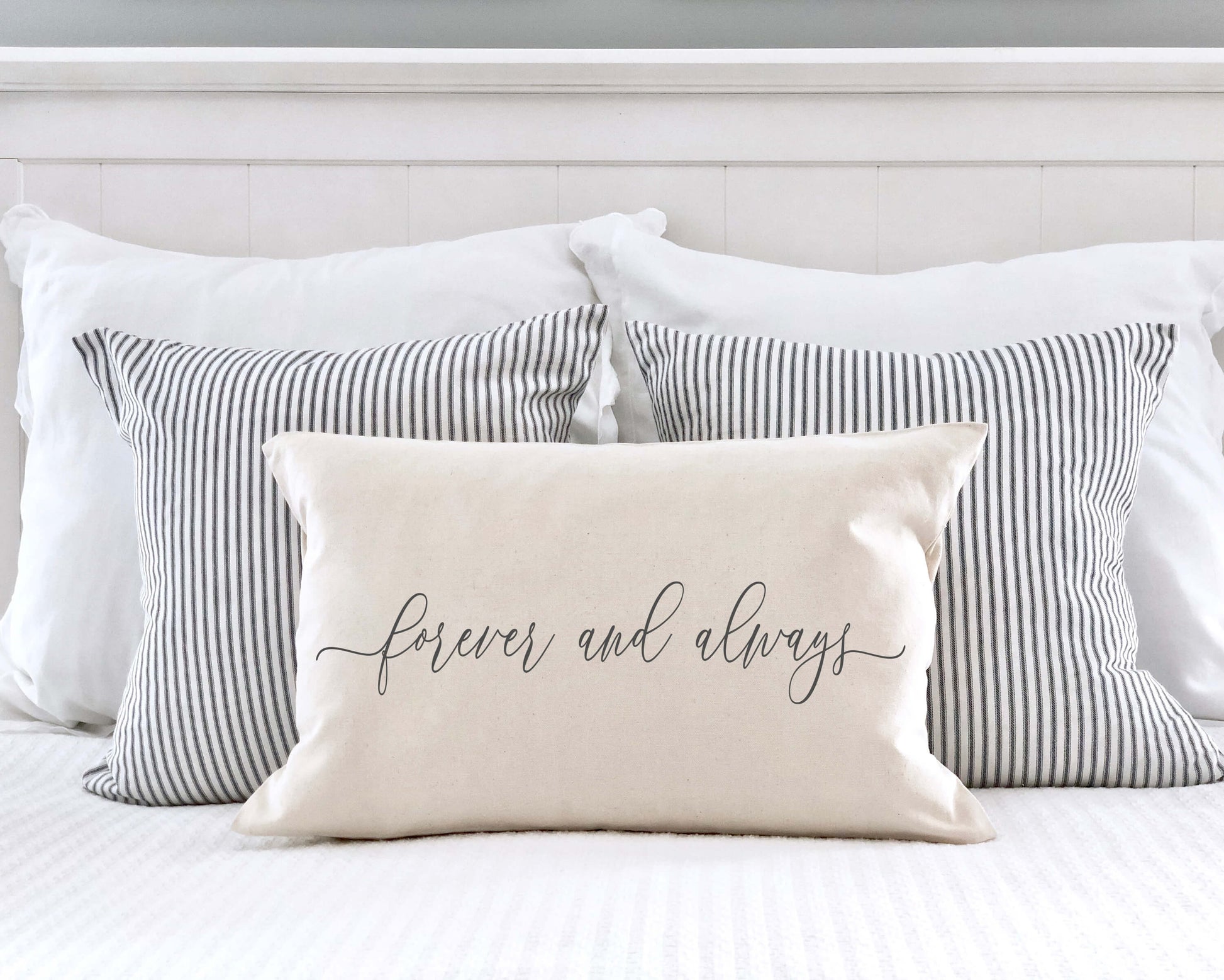 Forever and Always Valentine's Day Pillow Cover on a bed with striped pillows, perfect for Valentine's decor.